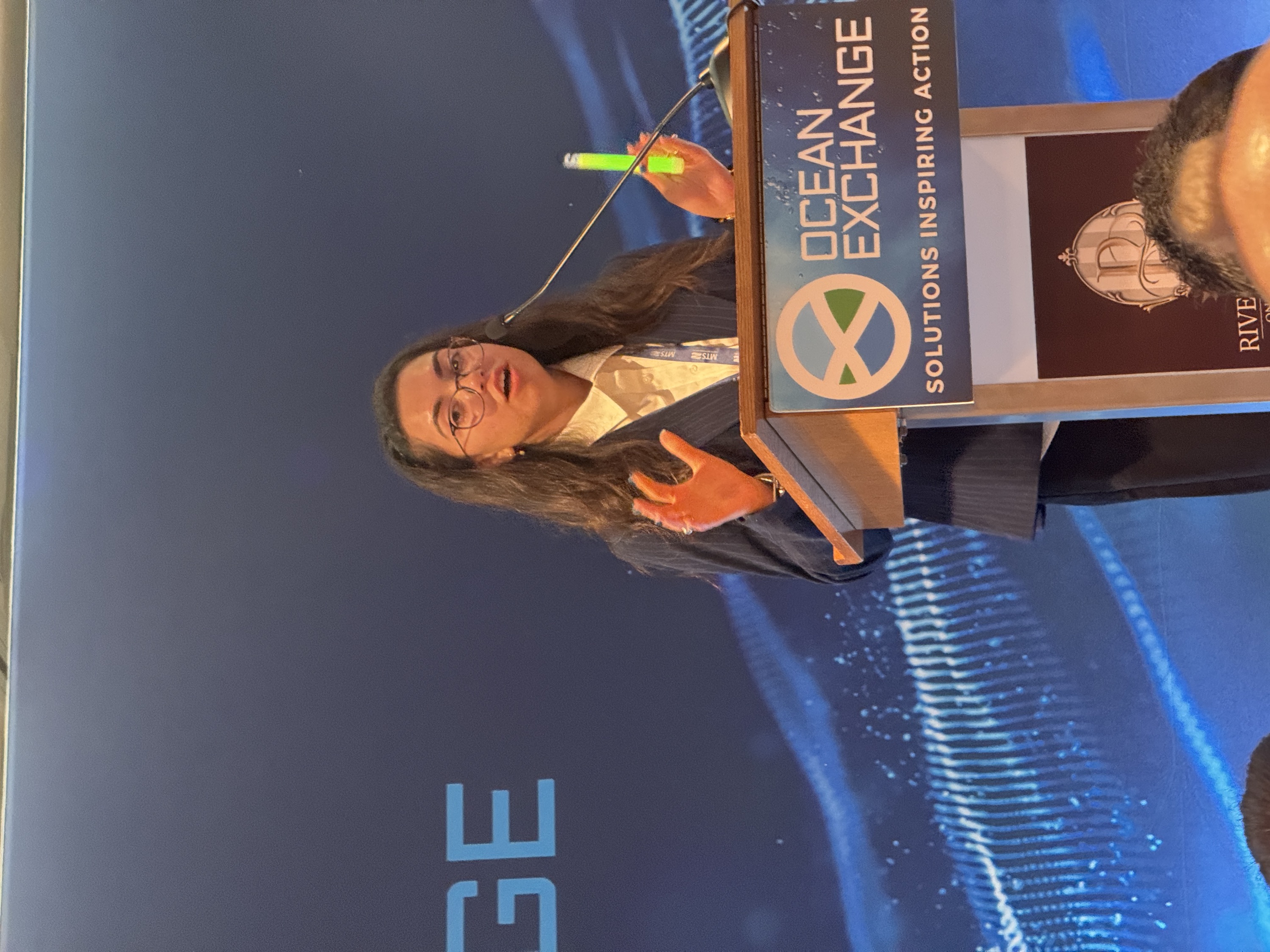 Gianna Galezo of Luminescent demonstrating bioluminescent fishing glow sticks at Ocean Exchange 2026
